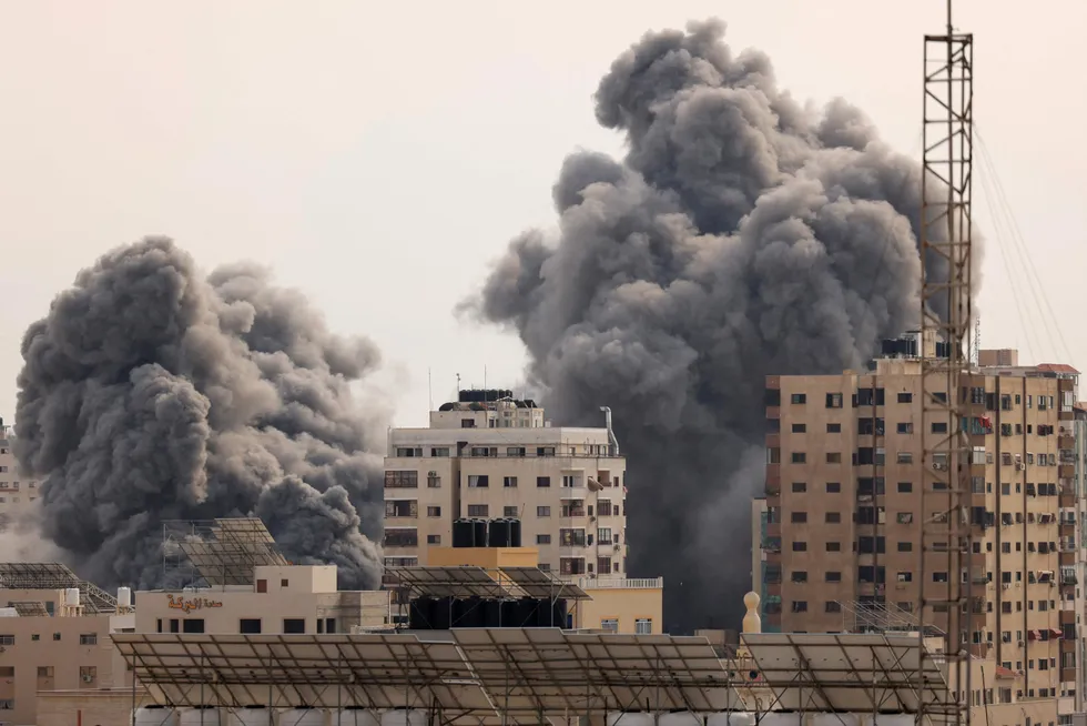 Escalation: A black plume of smoke billows behind high-rise buildings in the sky during an Israeli airstrike on Gaza City on 9 October.