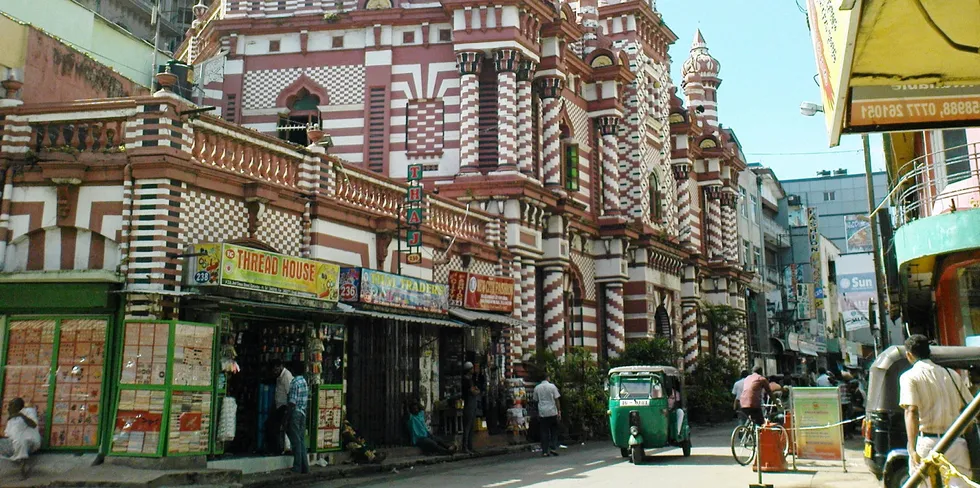 A tuc tuc passes the Jami Ul Alfar Jummah mosque in Colombo, Sri Lanka.