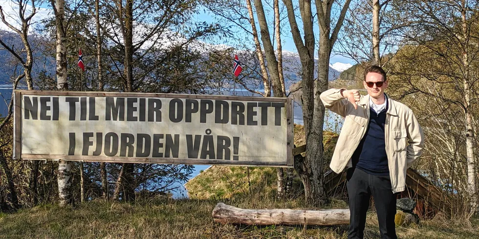 Falk Øveraas er samfunns- og myndighetskontakt i Ode. Her ved banneret som han plutselig så i en fjord.