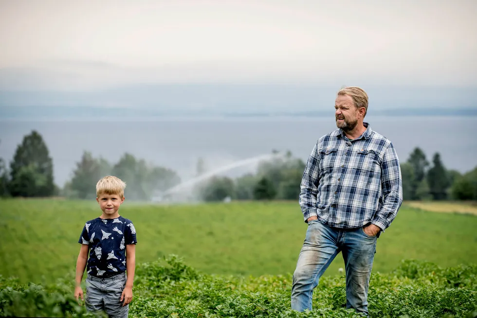 Per Odd Gjestvang og sønnen Håkon i en potetåker med et av vanningsanleggene i bakgrunnen. Grønnsaksbonden har delvis berget unna årets avlinger ved å pumpe opp vann fra Mjøsa.
