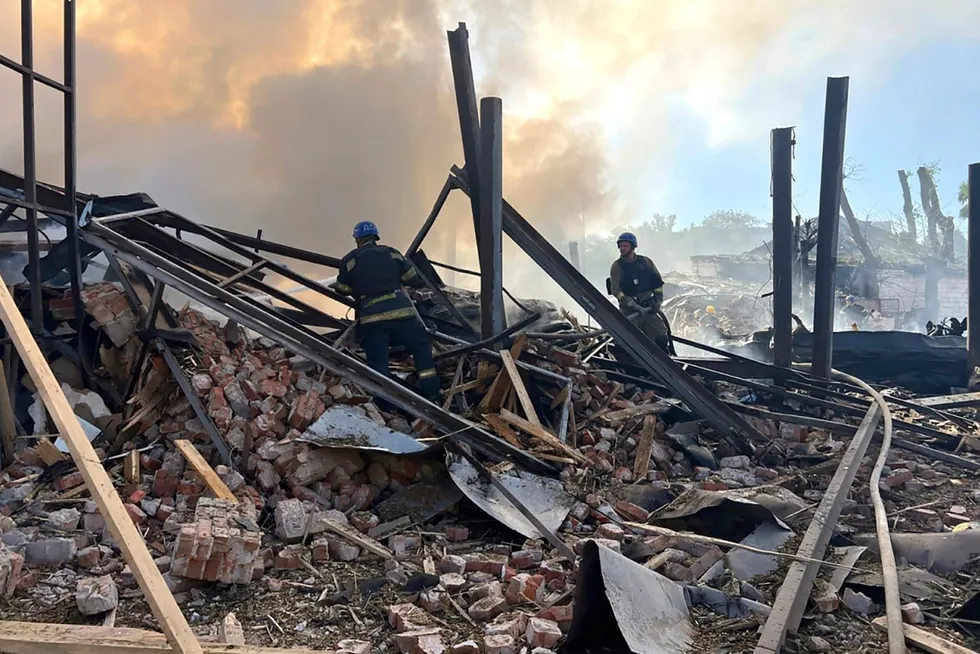 Ukrainske redningspersonell slukker branner etter et russisk angrep i Kryvyj Rih fredag.