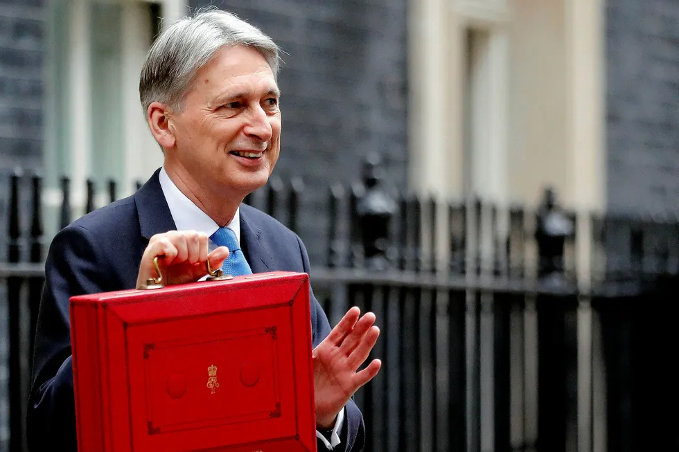 Budget day: UK Chancellor of the Exchequer Philip Hammond waves and poses for the media as he holds up the traditional red dispatch box, outside his official residence 11 Downing Street, before delivering his annual budget speech to Parliament