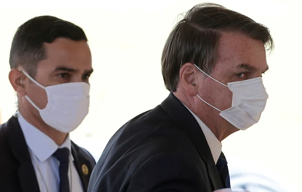 Brasils president Jair Bolsonaro på vei ut av sitt hjem Alvorada i Brasília mandag. Han fremholder at covid-19 ikke er verre en influensa og vil la folk gå til skjønnhetssalonger og på treningsstudio.