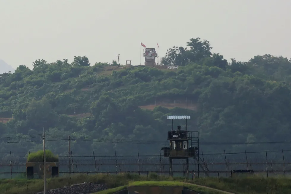 Nordkoreansk utkikkspost i bakgrunnen og sørkoreansk utkikkspost i forgrunnen. Kim Jong-un har besluttet å utsette planlagte militære handlinger mot Sør-Korea, ifølge KCNA.