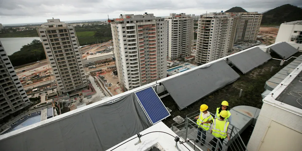 Construction takes place on a roof fitted with solar panels during a tour of the Ilha Pura housing complex, the site of the Athletes' Village for the Rio 2016 Olympic Games.