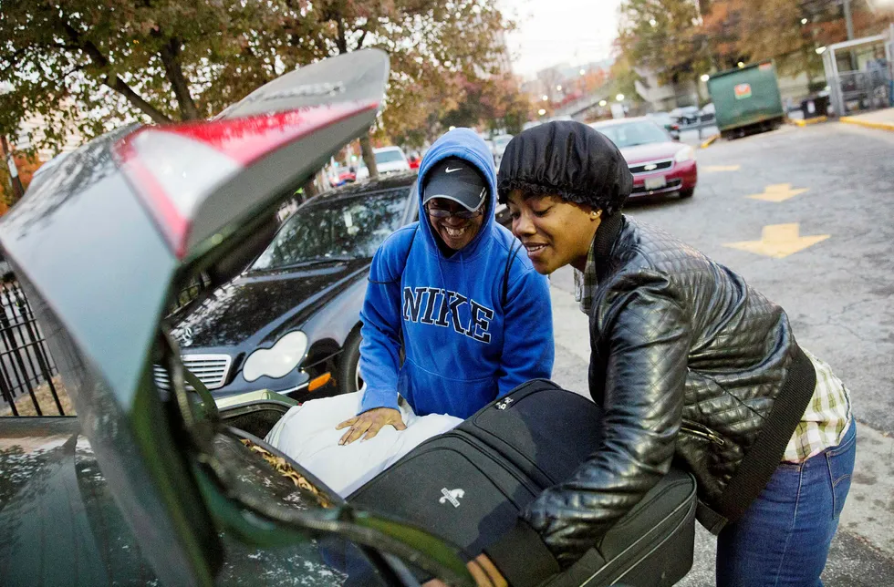 April Traylor (t.v.) hjelper datteren Latisha Brown med å legge bagasjen inn i bilen for å tilbringe Thanksgiving med henne i Atlanta. Rundt 50 millioner mennesker ventes å reise mer enn 50 amerikanske mil denne helgen, det meste siden 2007. Foto: David Goldman