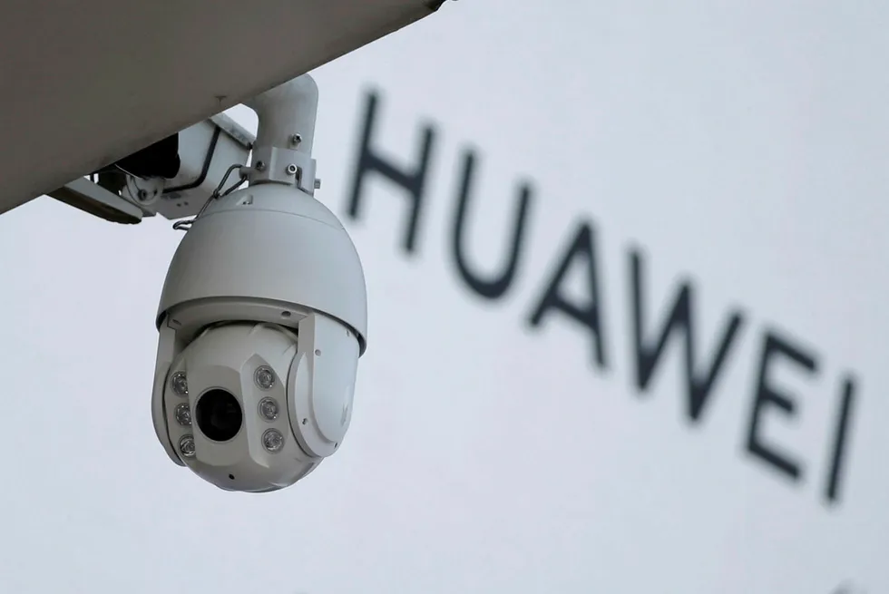 Hvordan uttales «Huawai»? (Og er det farlig å la teknologiselskapet være med på utbygging av 5G-nettet?). Bildet viser et overvåkningskamera utenfor et Huawei-skilt i Beijing.