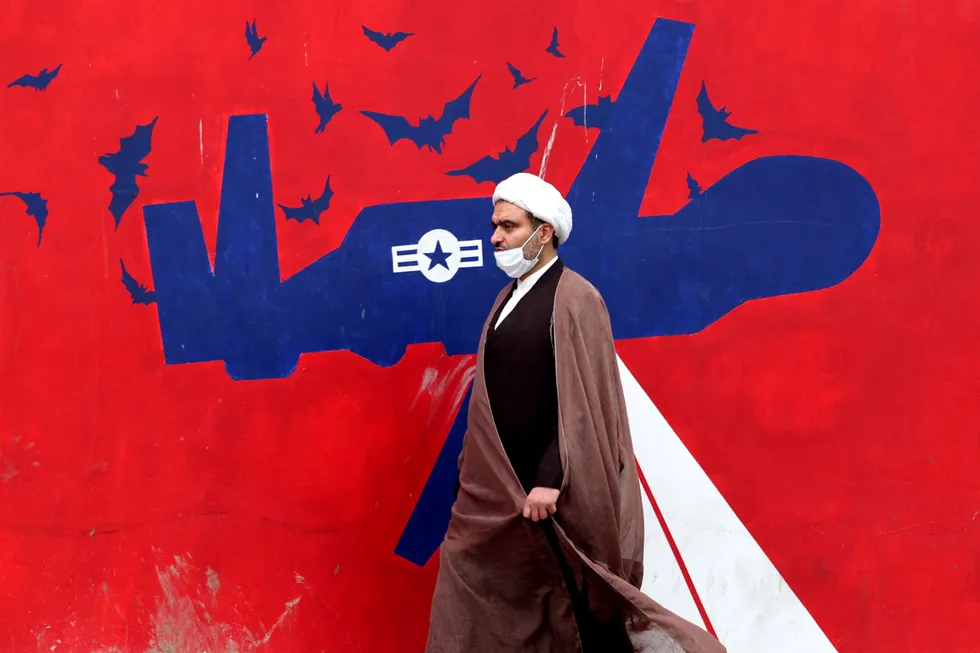 Changing relations: an Iranian cleric walks past an anti-US mural on a wall of the former US embassy in Tehran this week