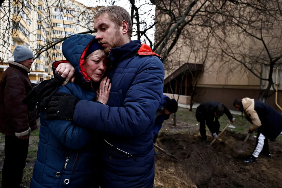 Serhii Lahovskyi (26) klemmer Ludmyla Verginska (51) i byen Butsja, der mange ukrainere skal ha blitt regelrett henrettet. Begge sørger over en felles venn som er blitt drept av russiske soldater. Begravelsen skjer i hagen ved en boligblokk.