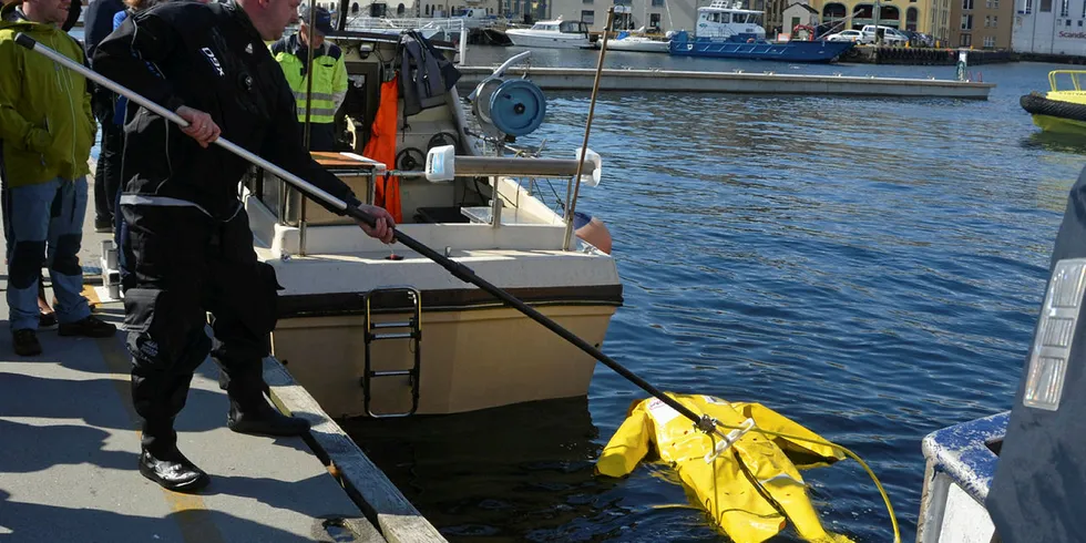 AR-BØYLEN: Losskipper og oppfinner Roger Brunsvik viste bruken av den nykonstruerte redningsstanga under konferansen Sikker fisker i Ålesund. Løkka tres inn fra beina.