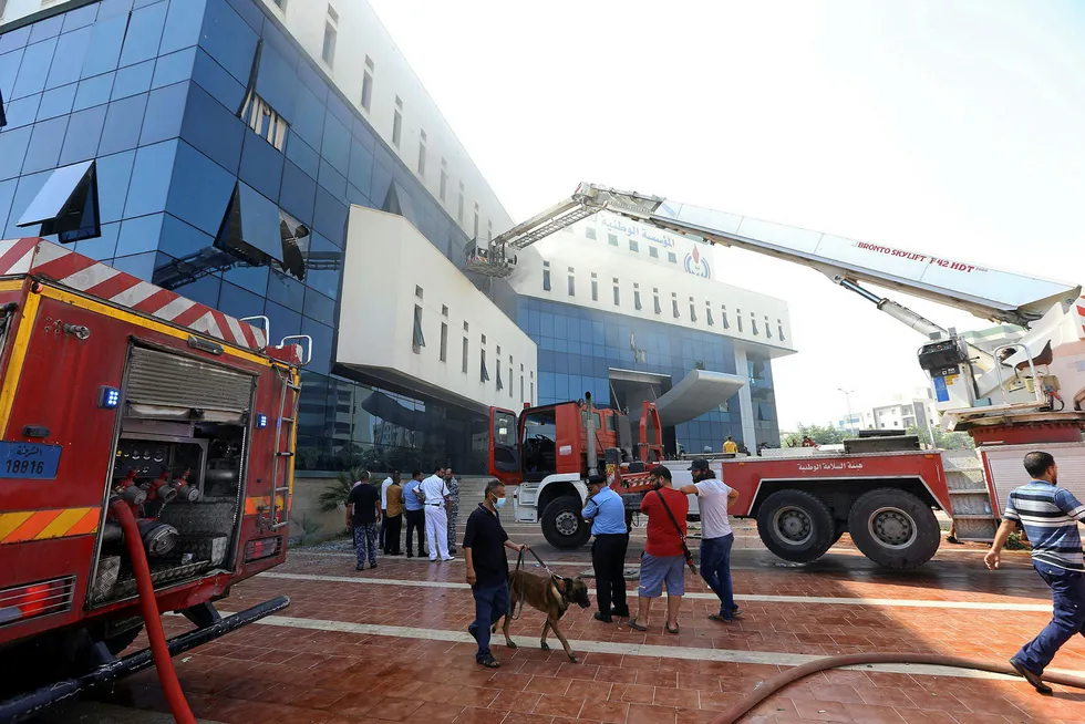 Aftermath: firefighters and rescuers gather in front of the NOC headquarters after the attack