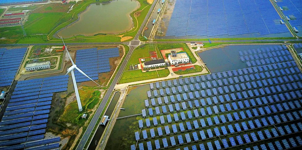 Aerial view of an industrial base consisting of wind turbines, solar panels and fish ponds at tidal flats in Yancheng, Jiangsu Province, China.