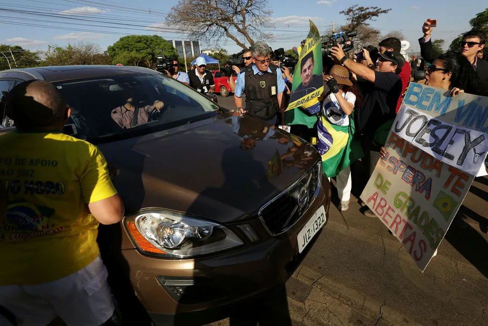 Demonstranter omringet bilen til JBS' tidligere styreleder Joesley Batistas advokat i Brasília mandag, dagen etter at Batista ble pågrepet. Onsdag ble også broren, JBS-direktør Wesley Batista, pågrepet av politiet. Foto: Eraldo Peres/AP/NTB Scanpix