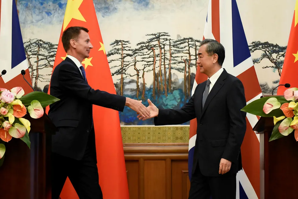 Storbritannias utenriksminister Jeremy Hunt tar Kinas utenriksminister Wang Yi i hånden etter en pressekonferanse i Beijing. Foto: Wang Zhao / AFP PHOTO / NTB Scanpix