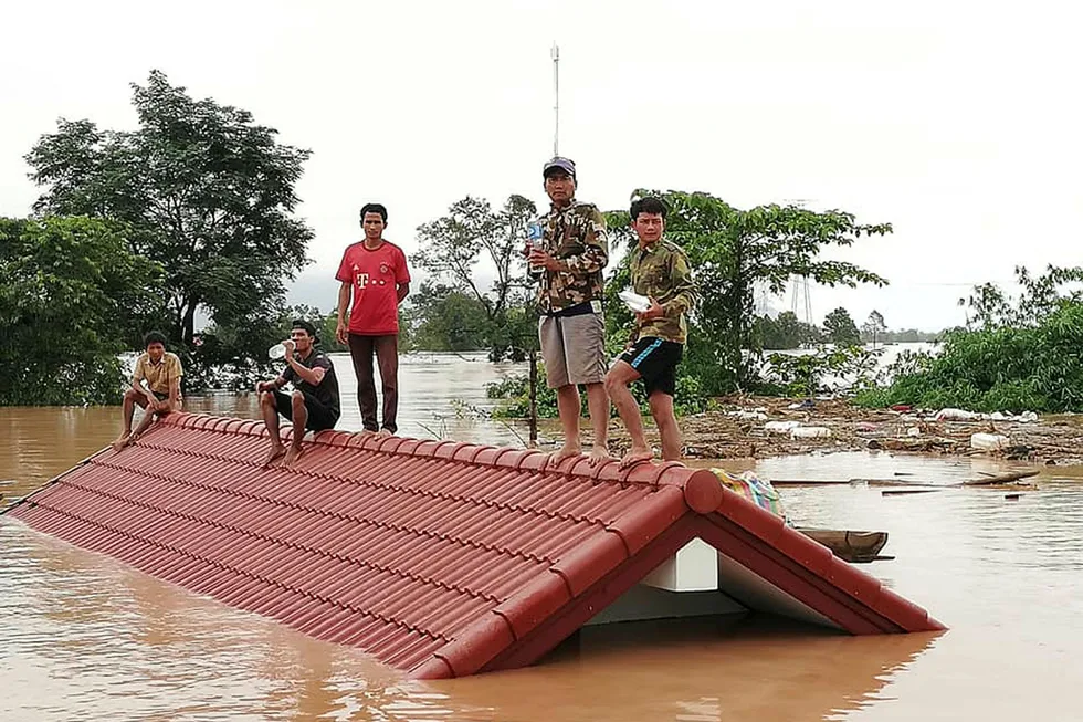 Stillbilde fra et TV-opptak som viser folk som evakueres fra det oversvømmede området sør i Laos. Foto: Attapeu tv via AP / NTB Scanpix