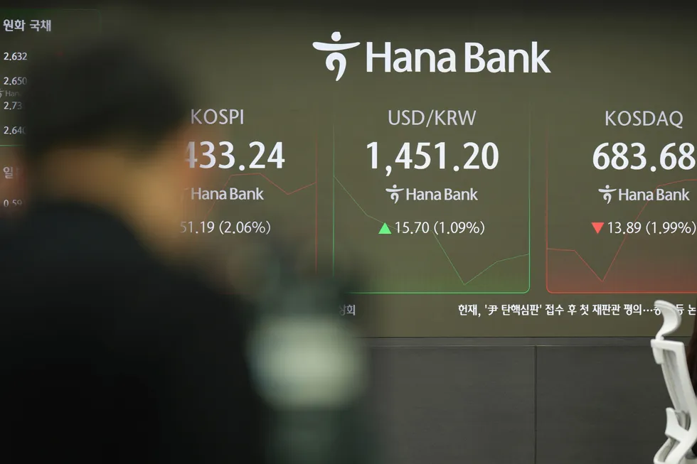 Tv cameraman films near the screens showing the Korea Composite Stock Price Index (KOSPI), left, the foreign exchange rate between U.S. dollar and South Korean won, center, and South Korean won and the Korean Securities Dealers Automated Quotations (KOSDAQ) at a foreign exchange dealing room in Seoul, South Korea, Thursday, Dec. 19, 2024. (AP Photo/Lee Jin-man)