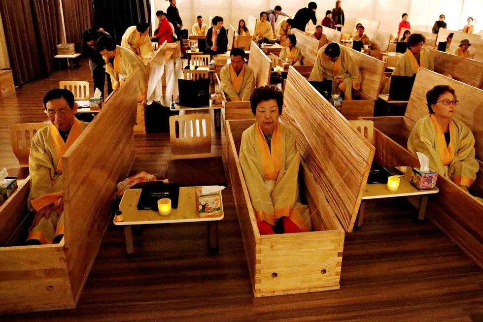 Participants sit inside coffins during a «living funeral» event as part of a «dying well» programme, in Seoul, South Korea, October 31, 2019. Picture taken on October 31, 2019. REUTERS/Heo Ran TPX IMAGES OF THE DAY ---