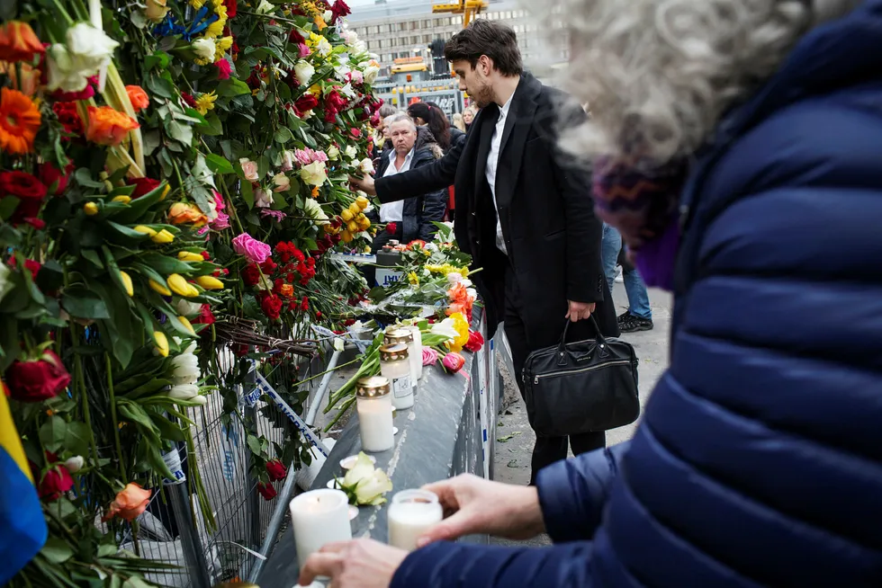 Befolkningen strømmet til området rundt Drottninggatan lørdag ettermiddag for å legge ned blomster. Foto: Linus Sundahl-Djerf