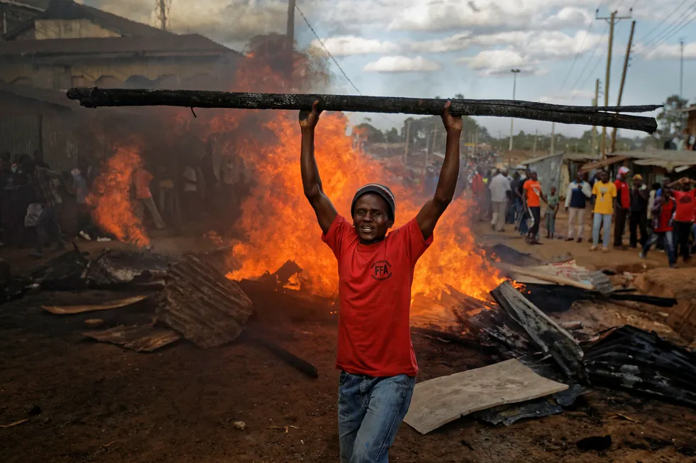 En opposisjonstilhenger foran en brennende barrikade som er laget av materialer fra en eiendom som tilhører en mann fra kikuyu-folket. President Uhuru Kenyatta tilhører kikuyu-folket. Foto: Ben Curtis / AP / NTB scanpix