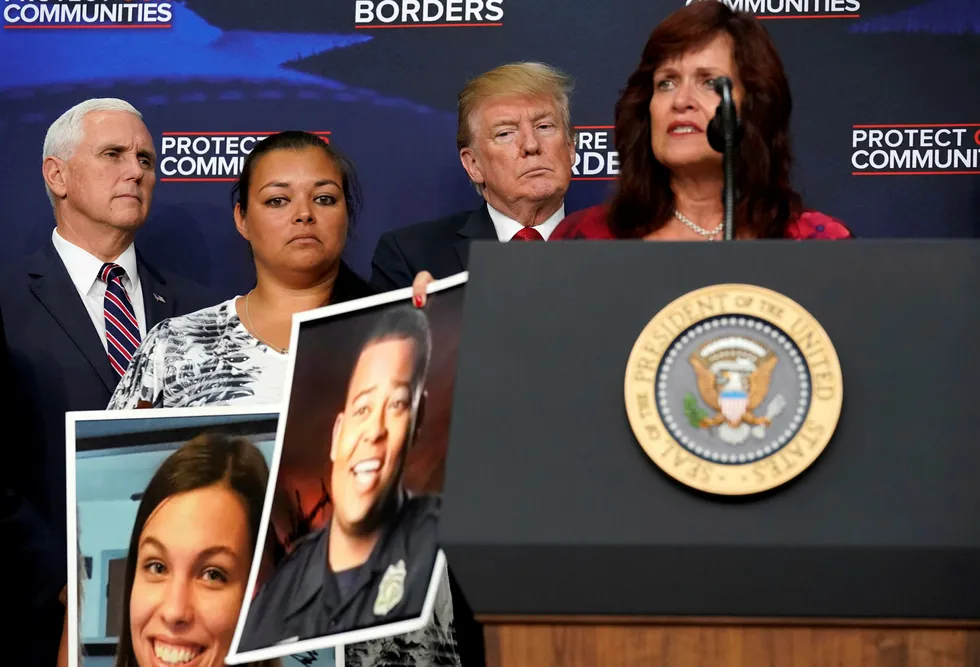USAs president Donald Trump og visepresident Mike Pence med ofre for påstått illegale innvandrere. Foto: KEVIN LAMARQUE/Reuters/NTB Scanpix
