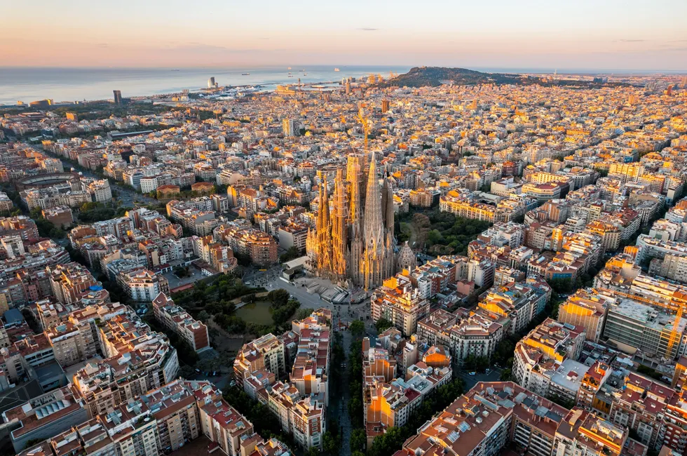 An aerial view of the city of Barcelona, featuring the landmark Sagrada Familia cathedral.