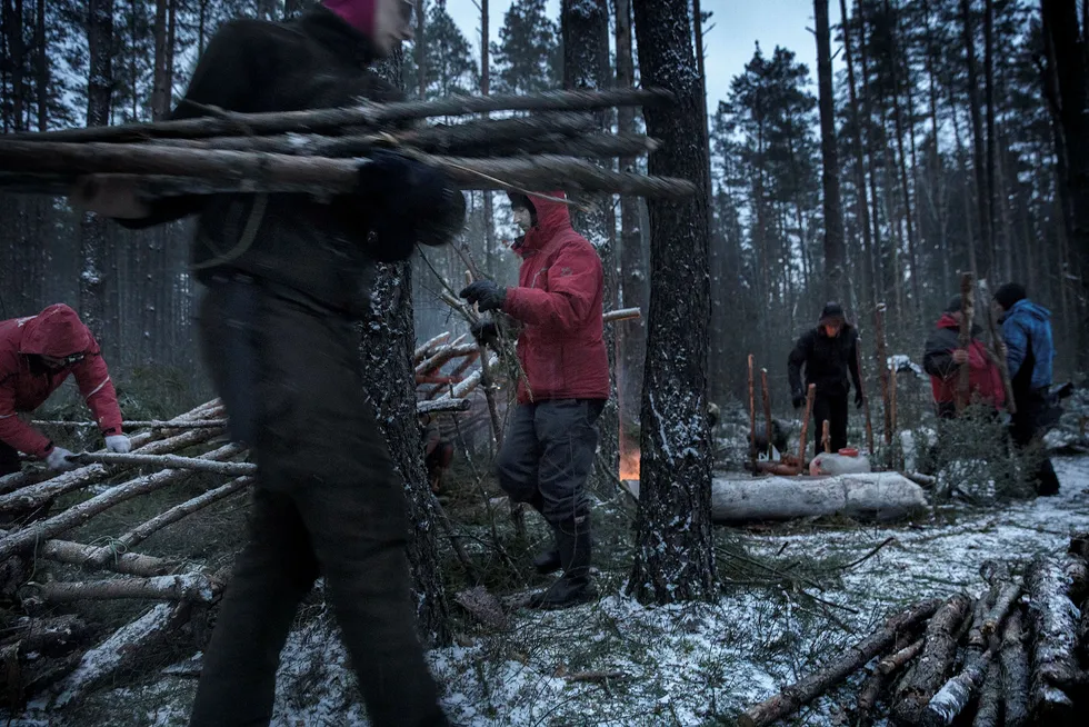 Slår leir. 12 menn flytter ut i skogen for å lære å overleve hvis russerne kommer. Granbar og stokker er allerede lagt klart av instruktørene på kurset, slik at sivilistene lett kan bygge leir.
