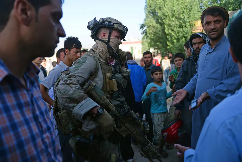 En norsk spesialstyrkesoldat snakker med lokalbefolkningen i Kabul i Afghanistan i 2013. Deltagelse i internasjonale operasjoner kan ikke forklare at det norske forsvaret er blitt dramatisk mindre.
