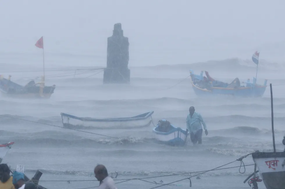 Devastation: a fisherman waits for help as he tries to move his boat to safer ground on the Arabian Sea coast near Mumbai on 17 May as Cyclone Tauktae hits