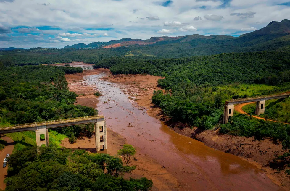 En bro er revet ned som følge av de massive mengdene gjørme som strømmer gjennom landskapet som følge av kollapsen i demningen.