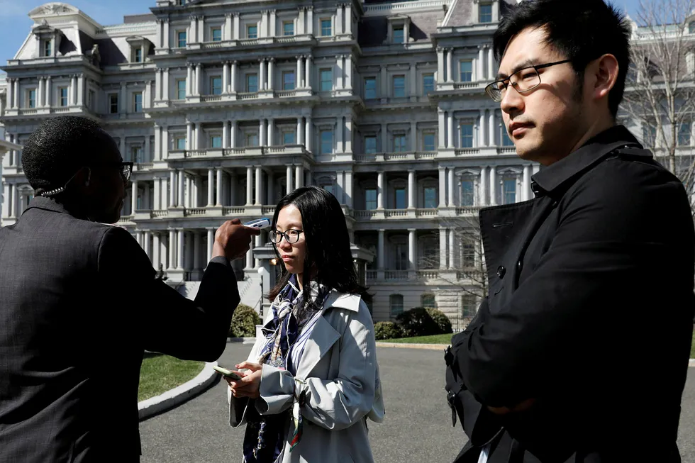 En kinesisk tv-reporter blitt sjekket for feber av sikkerhetsfolk utenfor Det hvite hus. Den kinesiske reporteren til høyre ble nektet adgang til president Donald Trumps pressekonferanse.