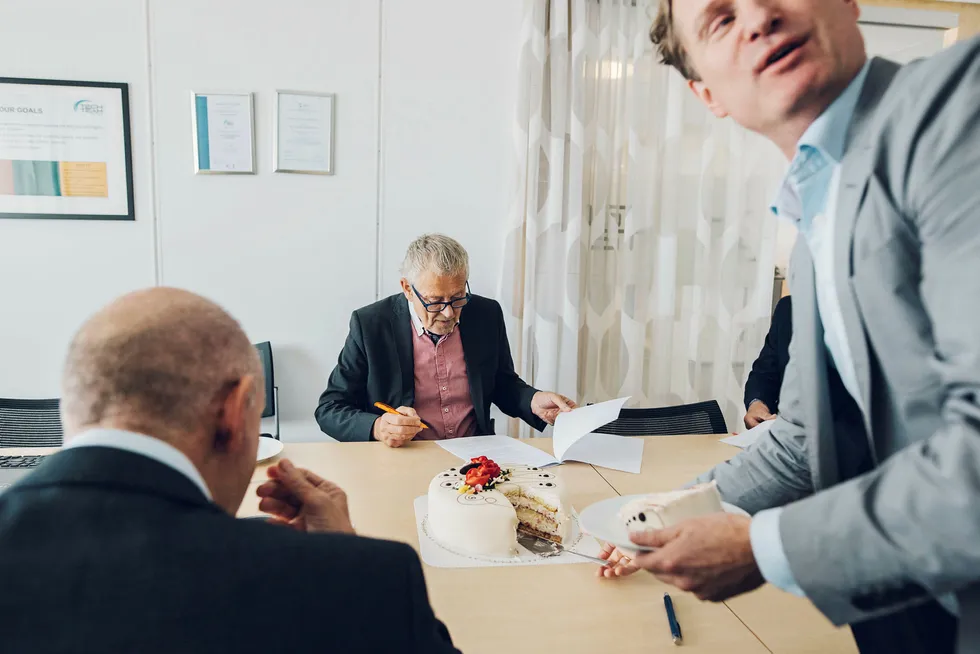 Finansdirektør i IKM Erling Meinich-Bache (til høyre) og IKM-eier Ståle Kyllingstad (til venstre) spiser kake etter å ha kjøpt Tech Team Solutions fra direktør Egil Tjelta og de andre eierne. Foto: Tommy Ellingsen