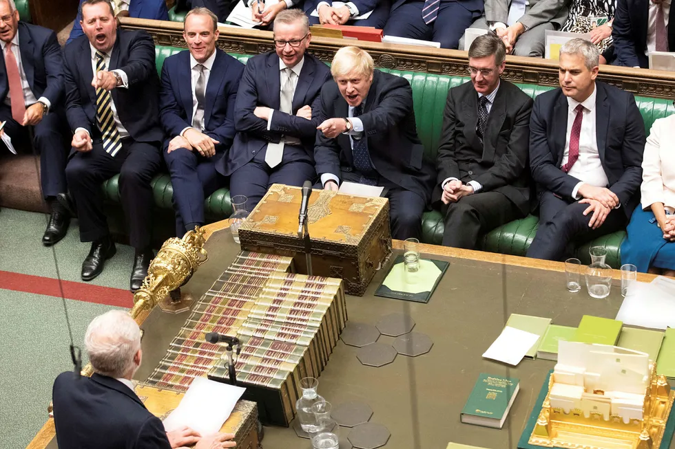 Storbritannias statsminister Boris Johnson ler og peker mot sin hovedmotstander Jeremy Corbyn under debatten i parlamentet tirsdag kveld.