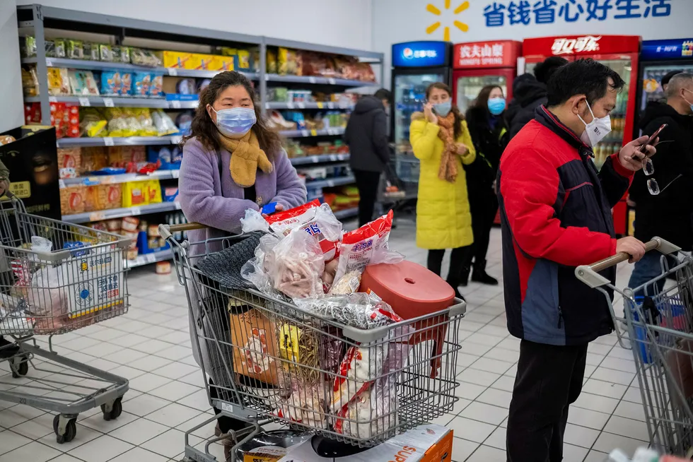 Hunkering down: Chinese residents buy groceries amid fears over the spreading coronavirus