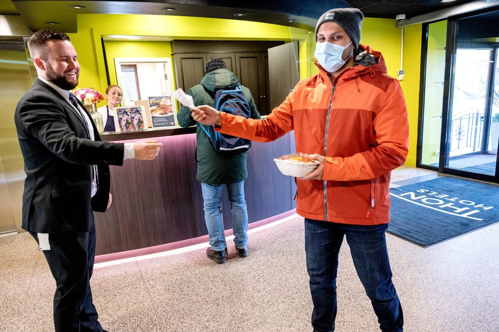 Hotellsjef Daniel Breivik i Thon Hotel Slottsparken (til venstre) gir bestikk til kunde Rohit Joshi som har sikret seg en forundringsporsjon med overskuddsmat fra frokostbuffeten.
