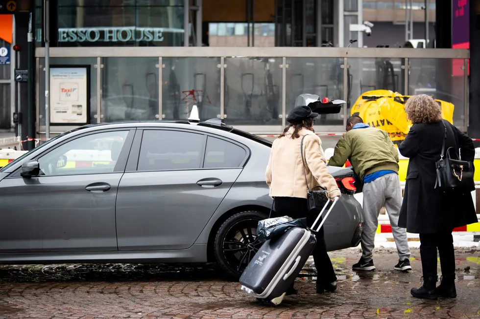 Et par kunder på vei inn i en taxi utenfor Jernbanetorget i Oslo sentrum.