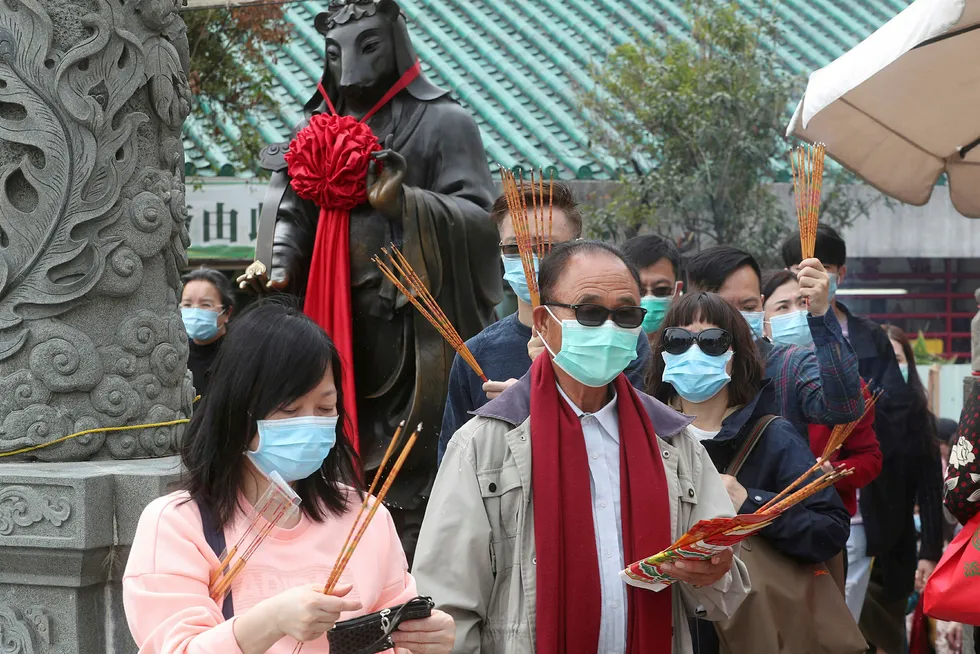 Besøkende var iført masker da de samlet seg ved Wong Tai Sin-tempelet i Hongkong lørdag for å be og feire nyttår. Foto: AP / NTB scanpix