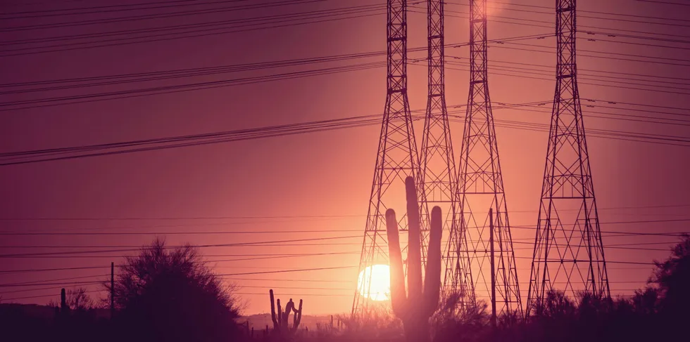 Power line poles running through the New Mexico desert at Sunset.
