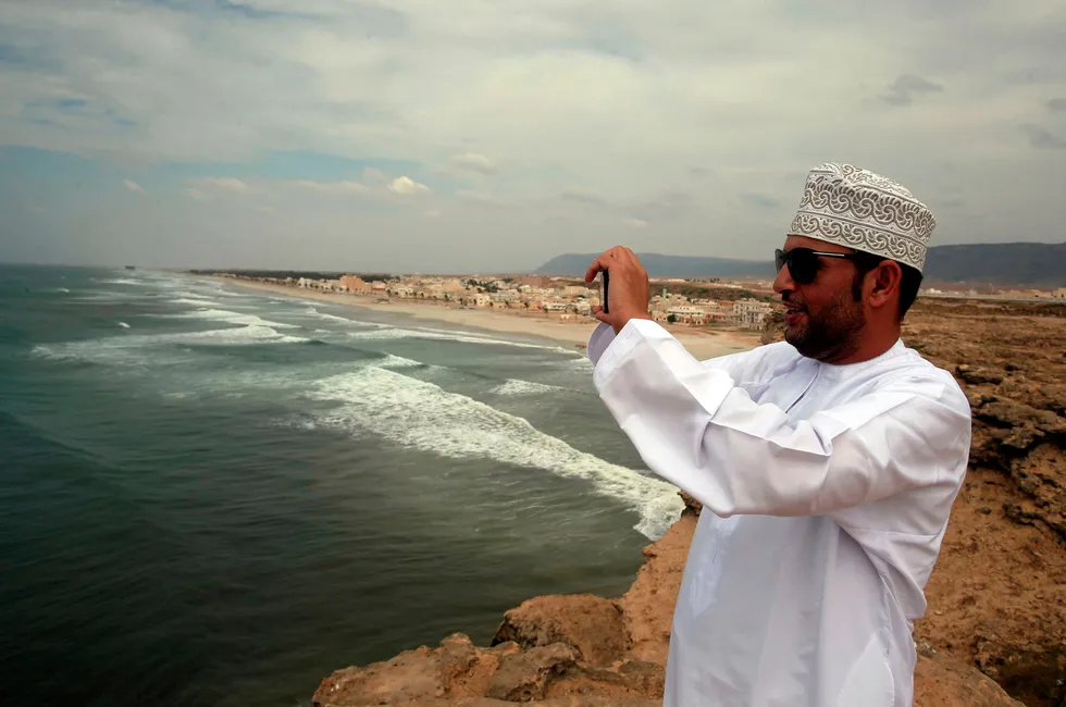 An Omani man takes a picture as waves crash on the shore of the southern port city of Salalah.