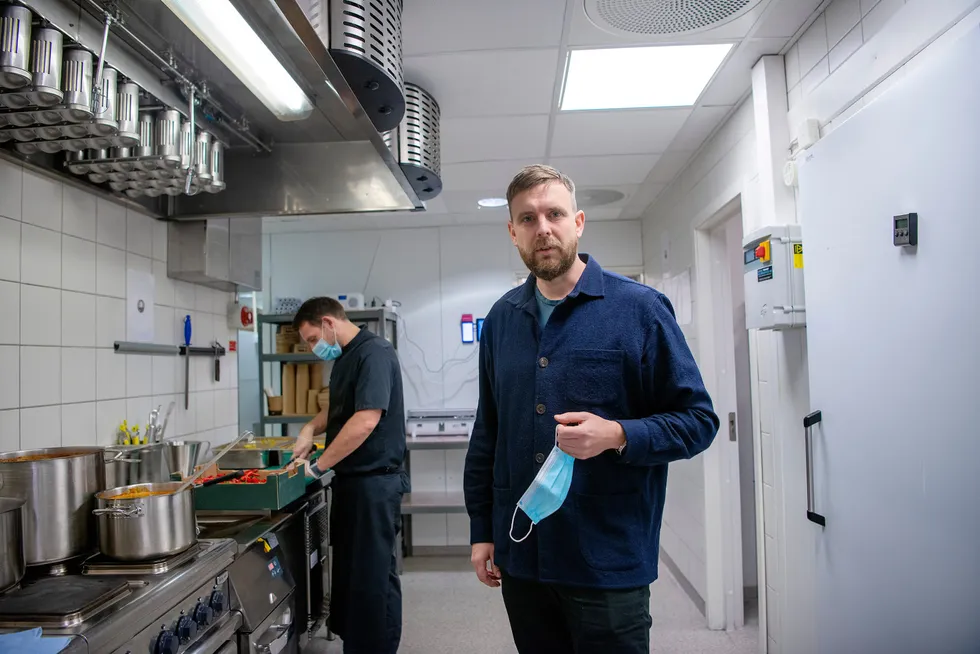 Gründer Jonas Stokke kaster masken et lite øyeblikk for fotografens skyld. I bakgrunnen forbereder kjøkkensjef (chief kitchen officer på start-up-språk) Sandor Camai maten.