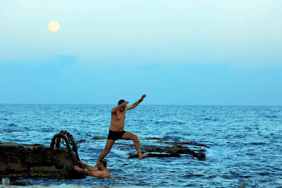 Taking a leap: a man jumps in the water on the seafront in Beirut