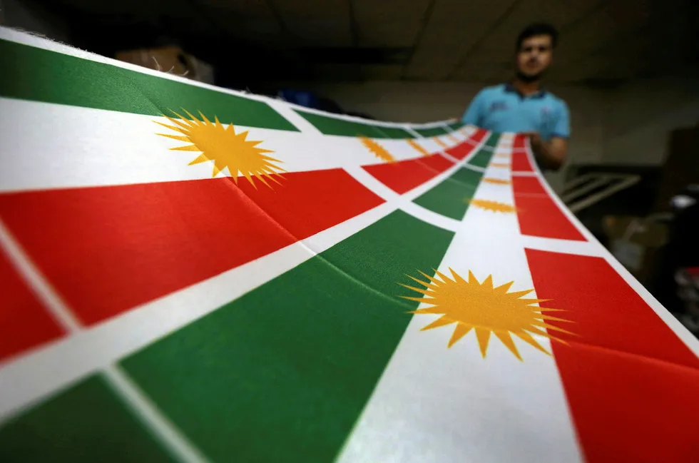 Building bridges: an Iraqi man prints a flag of Kurdistan