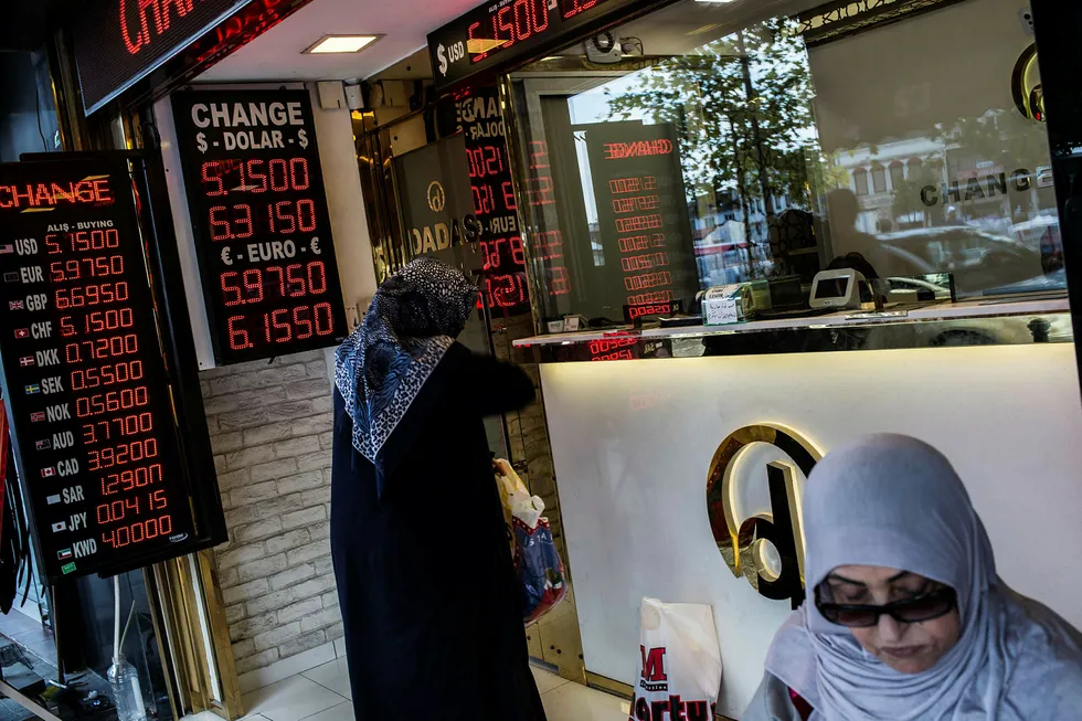 En dame veksler penger i Istanbul. Den tyrkiske valutaen har en inflasjon på 15 prosent.