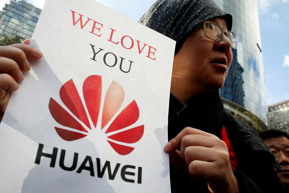 Lisa Duan, en besøkende fra Kina, holder opp en plakat som viser støtte til Huawei utenfor rettsbygningen i Vancouver i Canada der behandlingen om å løslate Huaweis finansdirektør Meng Wanzhou, skulle avgjøres.