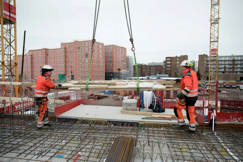 Veidekke bygger boliger i Gartnerkvartalet på Løren. Bilde er tatt i fjor vinter. Lars Gangnæs (til venstre) og Tobias Dahlin tar imot forskalingsplanker. Foto: Øyvind Elvsborg