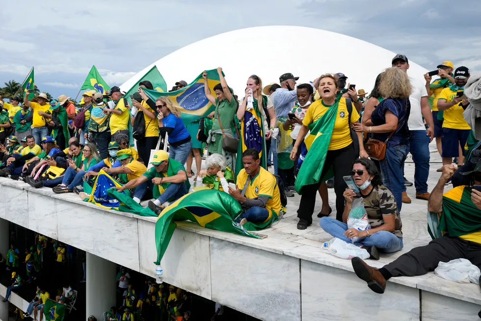 Smashing day: supporters of Brazil’s former president Jair Bolsonaro, stand on the roof of the National Congress building in Brasilia on Sunday.