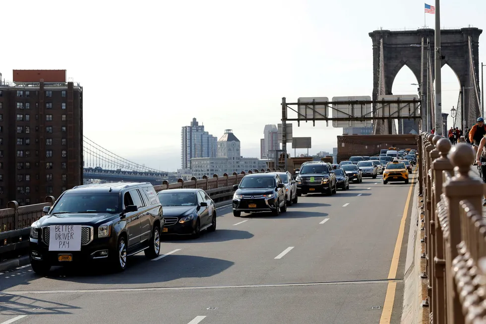Uber og Lyft-sjåfører krysset Brooklyn Bridge i New York med protestskilt på bilene onsdag.