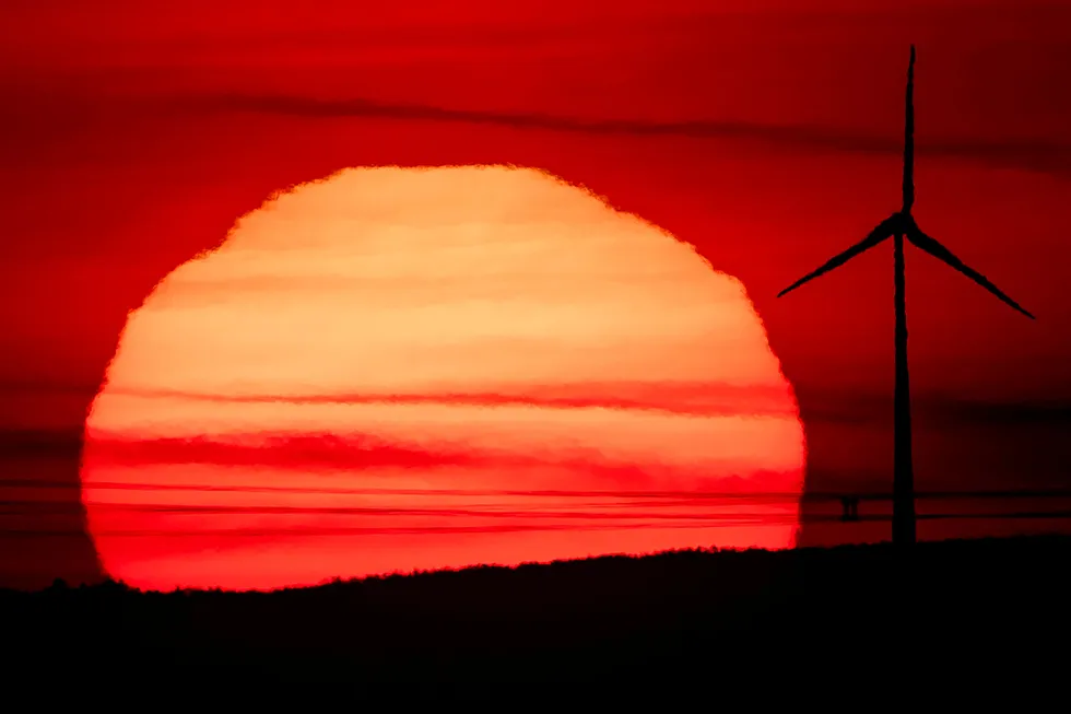 Feeling the transition heat: the sun rises behind a wind turbine in Frankfurt, Germany