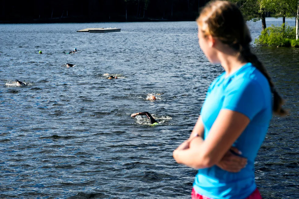 Svømmetrener Emma Augustsson ser ut over Sognsvann og triatletene som svømmer mot henne. Foto: Gunnar Lier