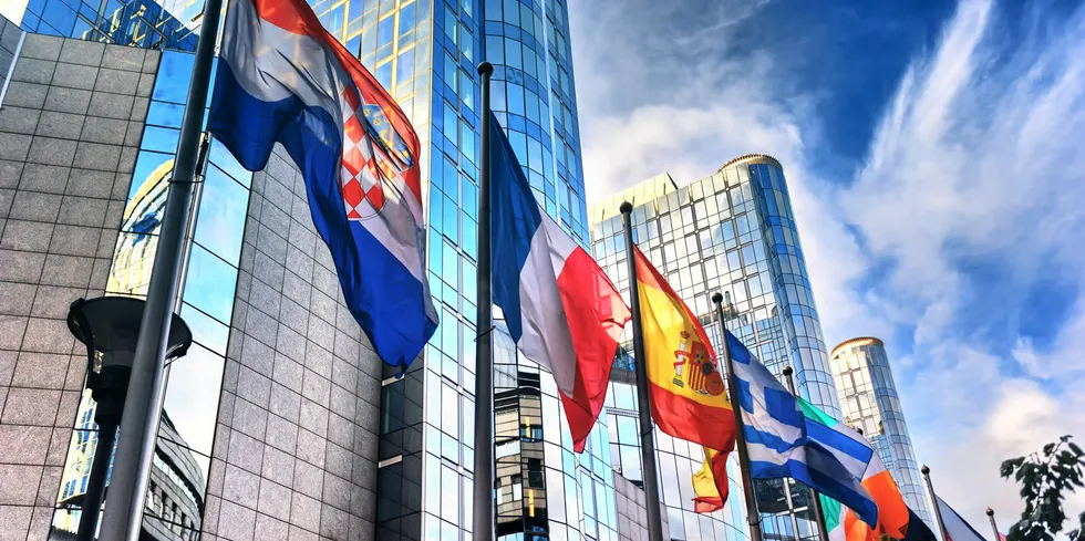 Waving flags in front of European Parliament building. Brussels, Belgium..