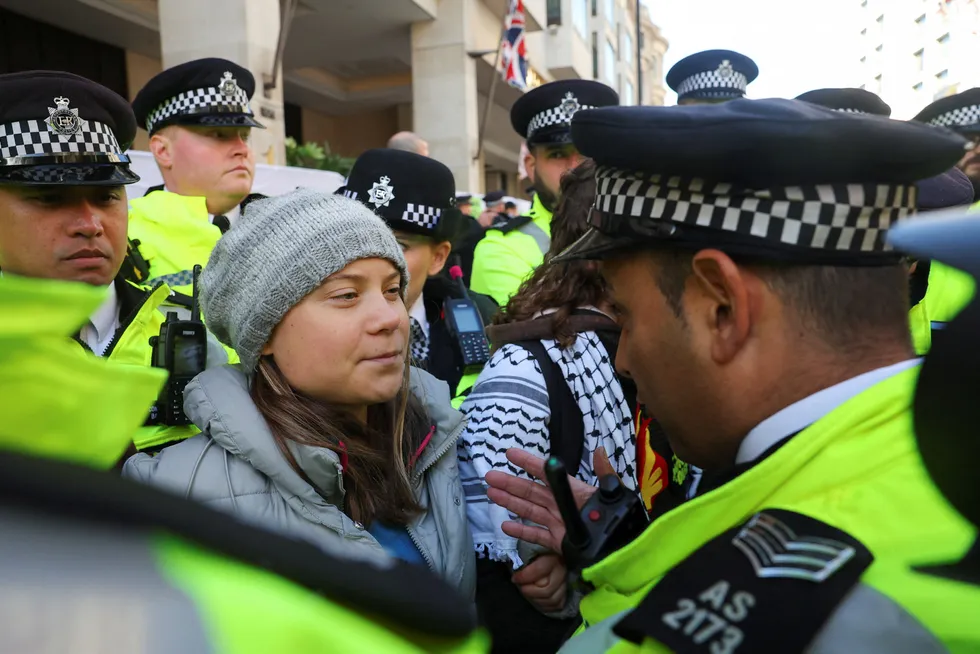 A police officer speaks with Swedish climate campaigner Greta Thunberg, during an Oily Money Out and Fossil Free London protest in London